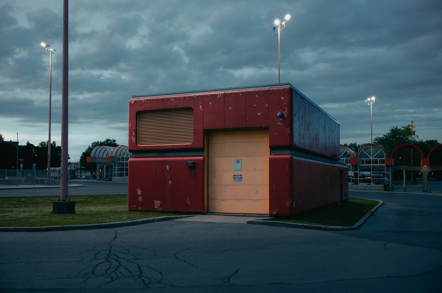 Rotes brutalistisches Betriebsgebäude an leerem Montréaler Busbahnhof in der Abenddämmerung
