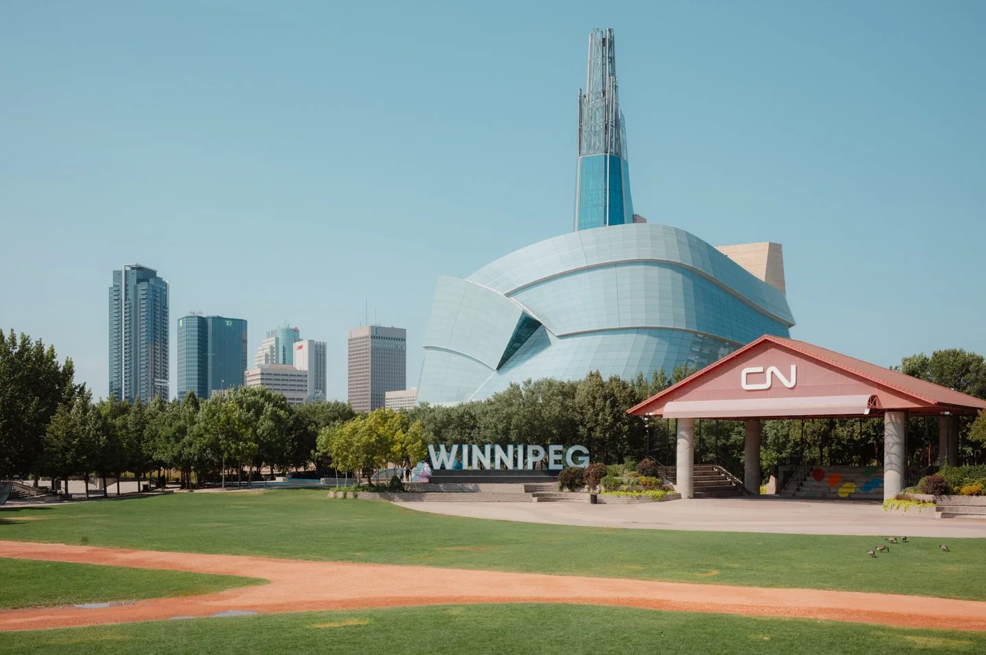 Canadian Museum for Human Rights und WINNIPEG-Schriftzug an den Forks in Winnipeg mit Skyline im Sommer